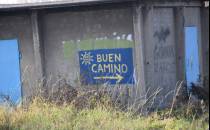 Graffiti Buen Camino na betonowym budynku.